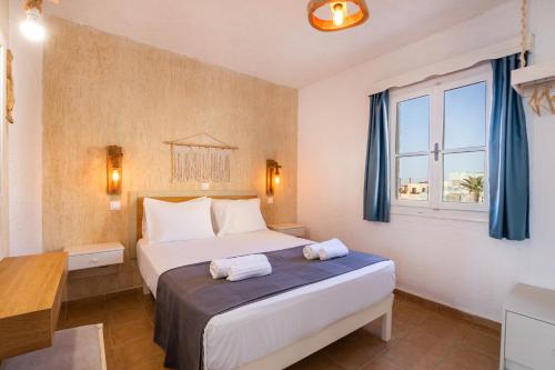 ein Hotelzimmer mit einem Bett und einem Fenster in der Unterkunft Elenis Studios in Arkasa