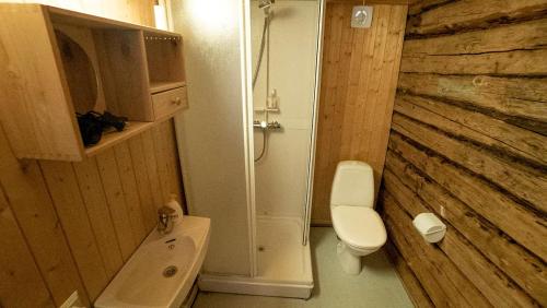 a bathroom with a white toilet and a shower at Real fisherman's cabins in Ballstad, Lofoten - nr. 11, Johnbua in Ballstad