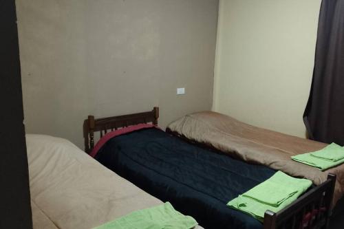 duas camas num quarto com toalhas verdes em Casa Laurel em Puerto Iguazú