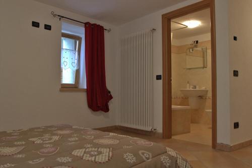 a bedroom with a bed and a bathroom at Casa Girod - Il Rustico in Issime