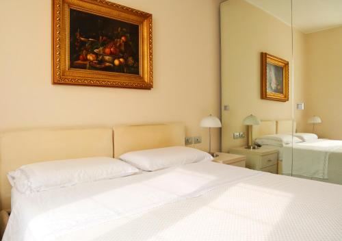 a bedroom with a bed and a painting on the wall at Repubblica Elegant Milan House in Milan