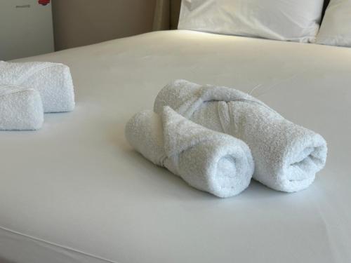 a white towel animal laying on a bed at PORT TWINS SUITES No1 in Piraeus