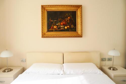 a bedroom with a bed with a painting on the wall at Repubblica Elegant Milan House in Milan
