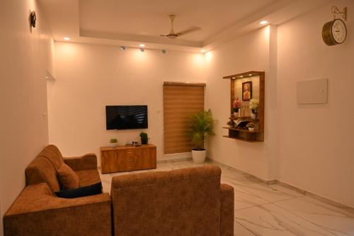 a living room with two chairs and a flat screen tv at Holiday Villa - Your Second Home - Kothamangalam in Kotamangalam