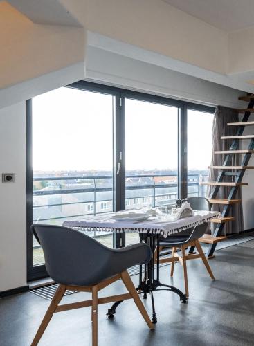 a dining room with a table and chairs and windows at B&B De Tulpentoren in Roelofarendsveen