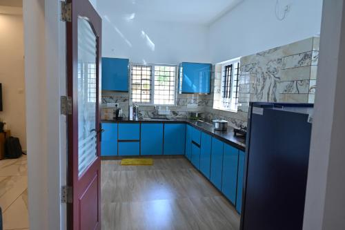 une cuisine avec des armoires et des comptoirs bleus dans l'établissement Holiday Villa - Your Second Home - Kothamangalam, à Kotamangalam