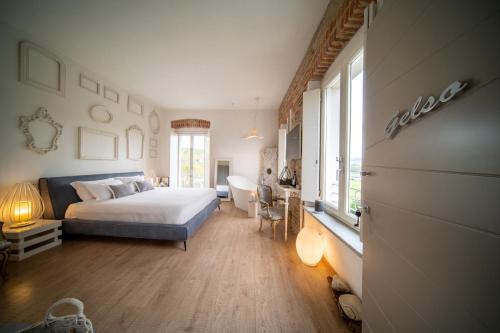 a bedroom with a bed and a desk in it at Langhe Country House in Neive