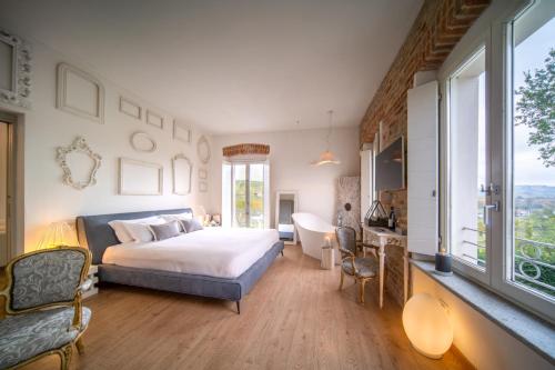 a bedroom with a bed and a desk and a sink at Langhe Country House in Neive
