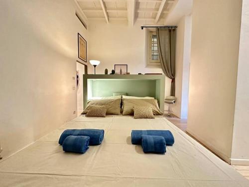 a large room with a bed with blue pillows on the floor at Near Ponte Vecchio: central luxury flat in Florence