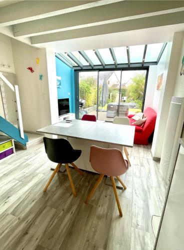 une salle à manger avec une table et des chaises blanches dans l'établissement Jolie petite maison à 500m de la plage d'Erdeven, à Erdeven