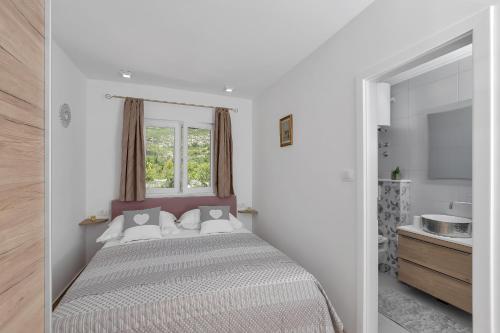 1 dormitorio con 1 cama con ventana y lavamanos en Holiday home Danica, en Ožići