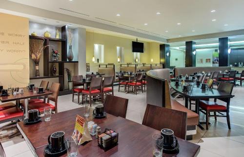 a dining room with tables and chairs in a restaurant at Holiday Inn Louisville Airport - Fair/Expo, an IHG Hotel in Louisville