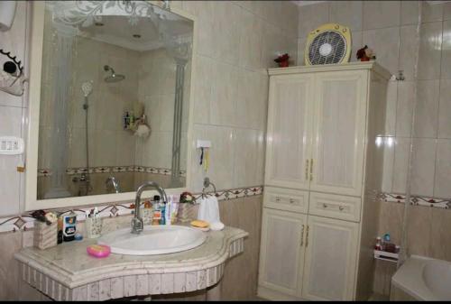 a bathroom with a sink and a mirror at شقه مفروشه مميزه in Cairo