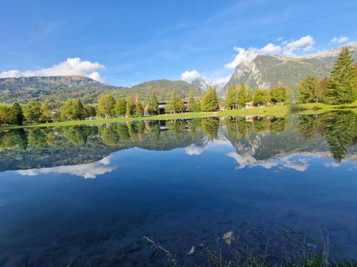 a view of a lake with mountains in the background at Charmant mobilhome à 2 pas remontés ski Samoëns in Samoëns