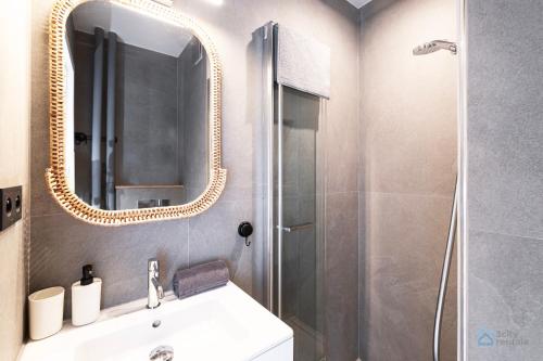 a bathroom with a sink and a shower with a mirror at Samba by 3City Rentals in Gdańsk