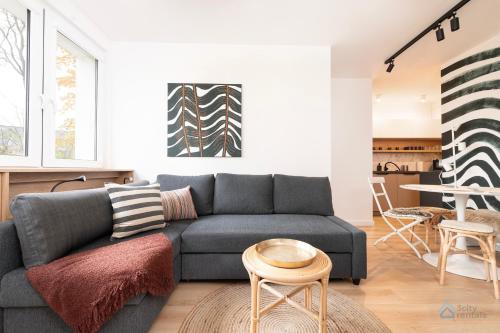 a living room with a couch and a table at Baltic Breeze Apartment 3city Gdańsk by Noclegi Renters in Gdańsk