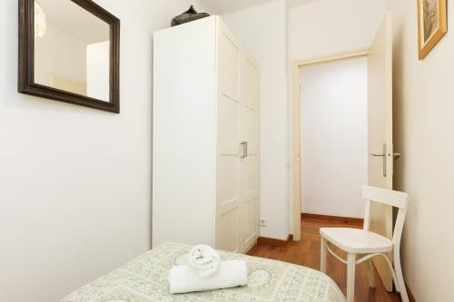 a bedroom with a bed and a mirror and a chair at Lodging Apartments Gracia 2 in Barcelona