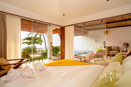 a bedroom with a bed with a view of the ocean at LA RÊVE The Beach Villa in Malappuram