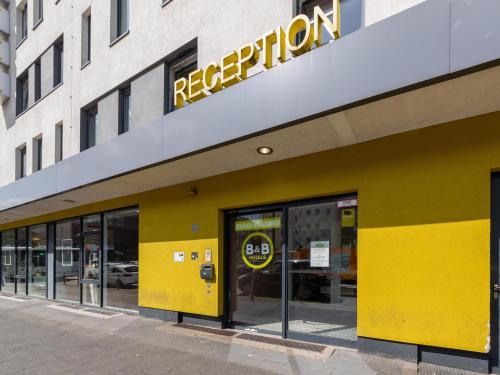 un front de magasin jaune avec un panneau. dans l'établissement B&B HOTEL Düsseldorf-Mitte, à Düsseldorf