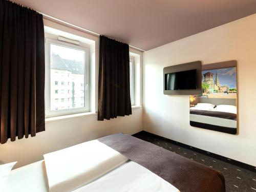 Un pat sau paturi într-o cameră la B&B HOTEL Düsseldorf-Mitte