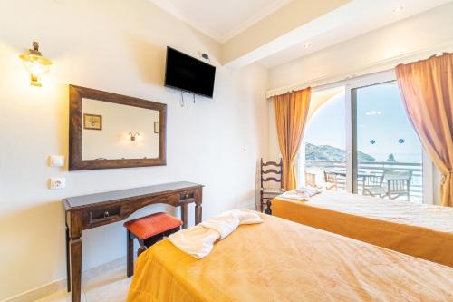 a hotel room with two beds and a mirror at Mazis Studio B2 in Agios Gordios