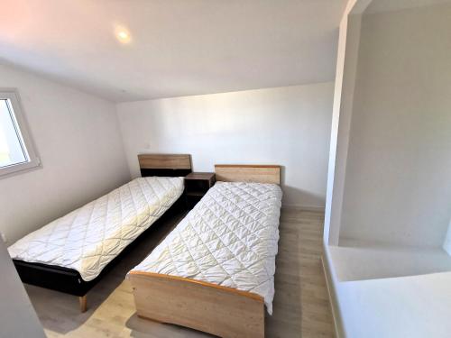 ein Schlafzimmer mit 2 Betten und einem Schreibtisch. in der Unterkunft La Maison Manole in Jard-sur-Mer