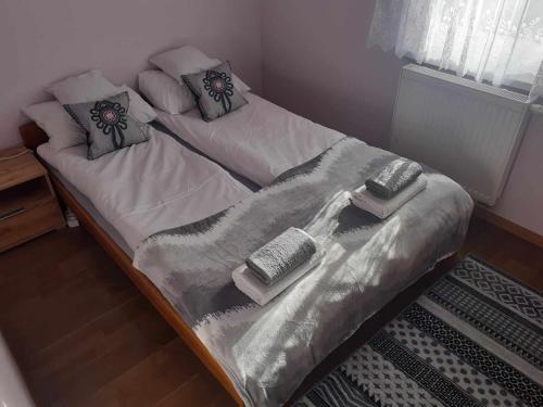 a bed with blankets and pillows on top of it at Lochówka - zaciszny domek w górach in Krynica Zdrój