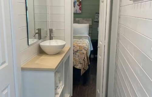 a bathroom with a sink and a mirror and a bed at Camptel Poconos in Albrightsville