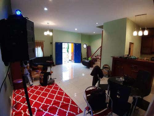 ein Wohnzimmer mit einem TV und einem roten Teppich in der Unterkunft Manyak Villa at Berastagi Resort C14 Jl Mimpin Tua in Berastagi