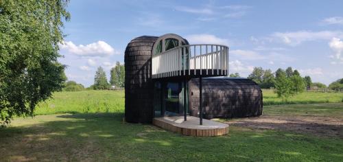 a circular building with a balcony in a field at Oiu sadama Iglupark in Oiu