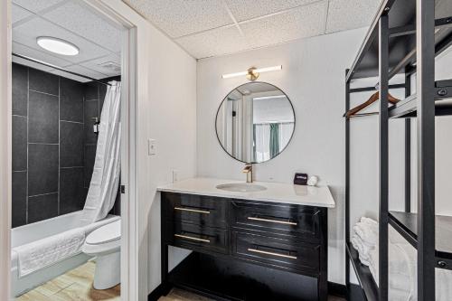 a bathroom with a sink and a mirror at The Mallard Hotel & Suites in Copperhill