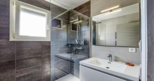 une salle de bain avec un lavabo et un miroir dans l'établissement Maison 4 personnes, Moëlan sur mer, proche plages, à Moëlan-sur-Mer
