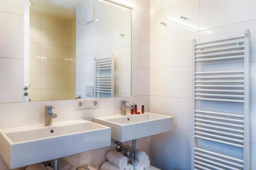 a bathroom with two sinks and a mirror at Residence Bellevue - incl Summercard in Zell am See
