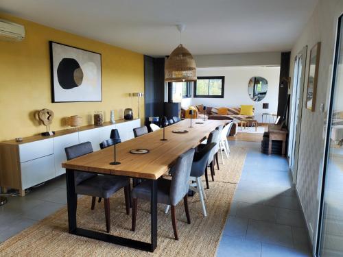 comedor y cocina con mesa larga y sillas en Maison des Coteaux blancs, en Chaudefonds-sur-Layon
