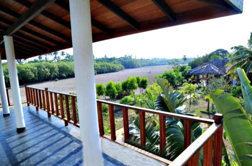 un balcón de una casa con vistas al río en Pearl Cave Cabanas & Resturant, en Tangalle