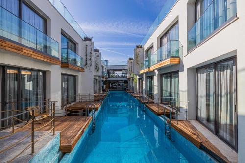 a swimming pool in a building with windows at Gözegir Hotel in Bodrum City