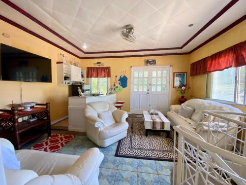 ein Wohnzimmer mit weißen Möbeln und gelben Wänden in der Unterkunft La Casa Blanca Binoclutan Beach Resort in Botolan