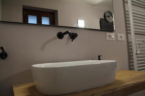 a bathroom with a white sink and a mirror at Miravigne House - Casa di Campagna con Cucina in Castagnole Lanze