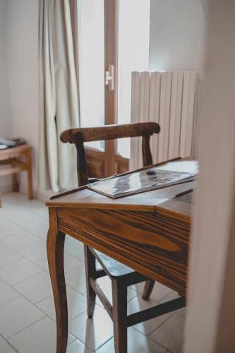 a wooden desk with a chair and a book on it at Bed & Breakfast Gabriella EXILLES in Exilles