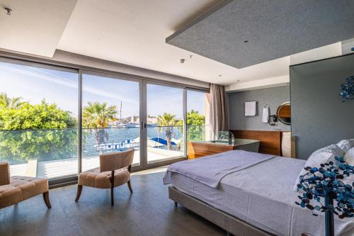 a bedroom with a bed and a view of the water at Gözegir Hotel in Bodrum City