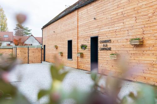 a brick building with doors and potted plants on it at Le Domaine de la Clarté AUXERRE - VENOY in Auxerre