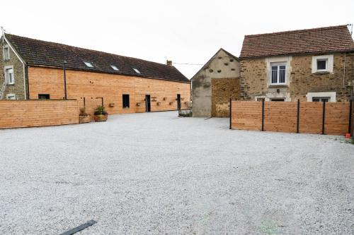 un grand parking avec deux bâtiments en briques dans l'établissement Le Domaine de la Clarté AUXERRE - VENOY, à Auxerre