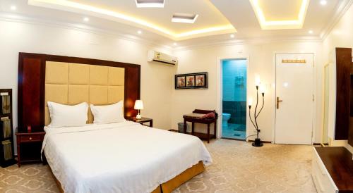 فندق لمسات نجران في نجران: غرفة نوم مع سرير أبيض كبير في غرفة