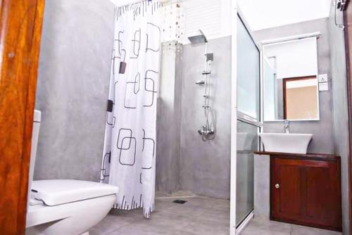 ein Bad mit einer Dusche, einem WC und einem Waschbecken in der Unterkunft Ran Dhara Beach Resort in Ambalangoda