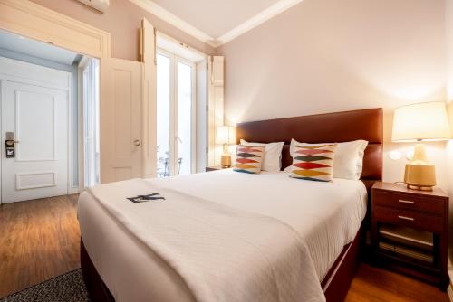 sypialnia z dużym białym łóżkiem i oknem w obiekcie Chiado Camões Apartments | Lisbon Best Apartments w Lizbonie