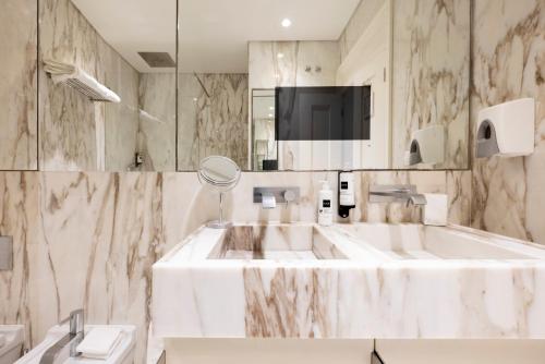biała łazienka z umywalką i lustrem w obiekcie Chiado Camões Apartments | Lisbon Best Apartments w Lizbonie