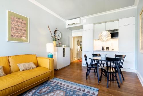 a living room with a yellow couch and a table at Chiado Camões Apartments | Lisbon Best Apartments in Lisbon