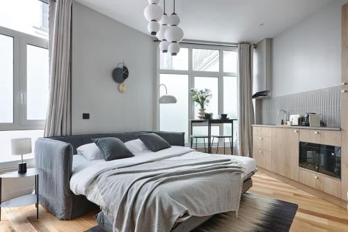 une chambre avec un grand lit et une cuisine dans l'établissement MyKeypers - Luxury Studio 2P - Marais/Bastille, à Paris