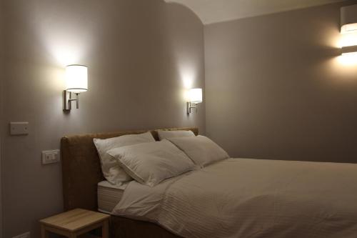 a bedroom with a bed with two lights on the wall at Miravigne House - Casa di Campagna con Cucina in Castagnole Lanze