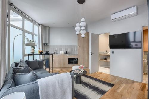 un salon avec un canapé et une cuisine dans l'établissement MyKeypers - Luxury Studio 2P - Marais/Bastille, à Paris